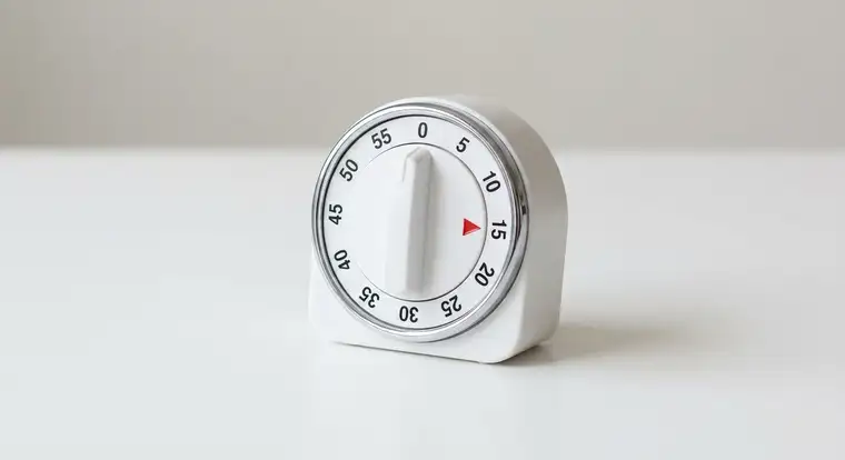 Osoba pracująca nad raportem w Excelu z widocznym zegarem i blokami czasowymi ilustrująca timeboxing i skrócenie czasu raportowania