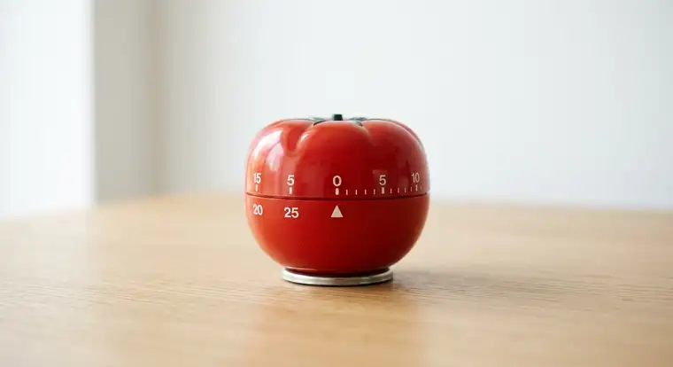 Pracownik biurowy używa minutnika i listy zadań, stosując metodę Pomodoro i deep work, aby zwiększyć skupienie w pracy biurowej