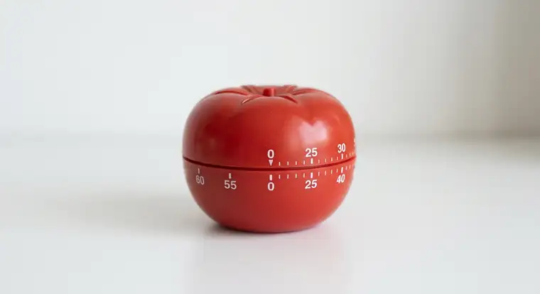 Programista full remote przy biurku z timerem Pomodoro, planujący długość sesji pracy w 2026 roku z użyciem narzędzi AI do kodowania